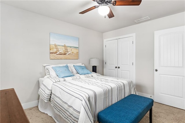 bedroom with baseboards, visible vents, a closet, and light carpet