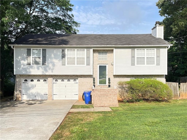 raised ranch with brick siding, driveway, a chimney, and a garage
