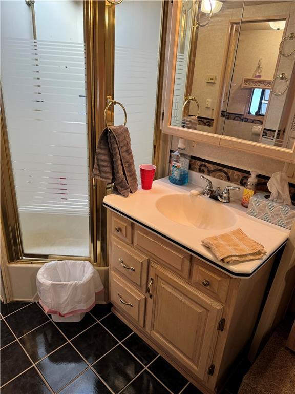 bathroom with vanity, bath / shower combo with glass door, and tile patterned flooring