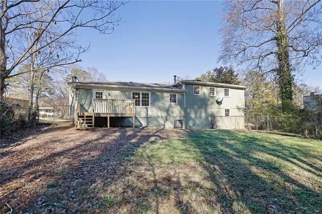 back of property with a deck and a lawn