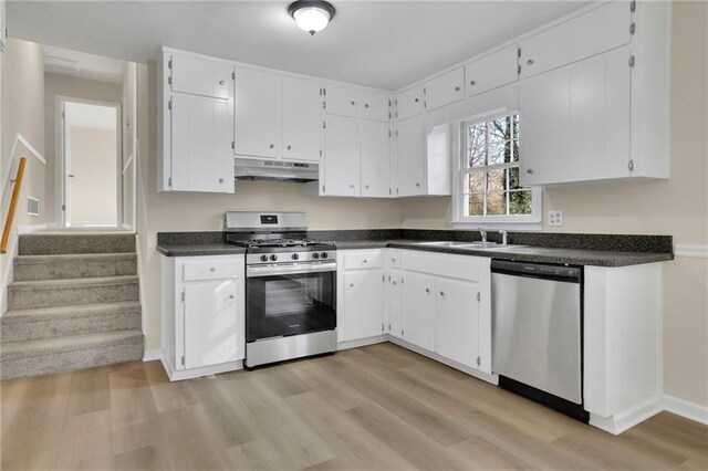 kitchen with light wood-type flooring, stainless steel appliances, white cabinetry, and sink