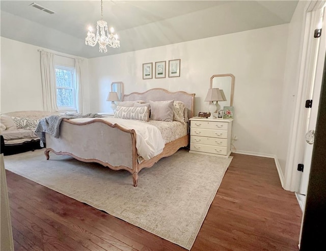 bedroom featuring dark hardwood / wood-style flooring and a chandelier