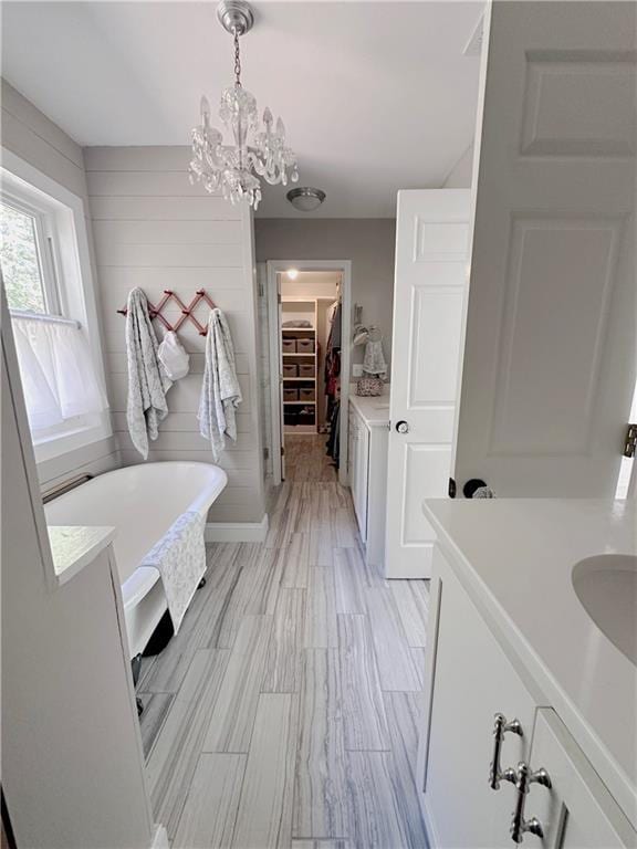 bathroom with vanity, a washtub, and a chandelier