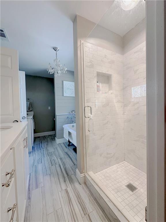 bathroom featuring vanity, a chandelier, and a shower with shower door