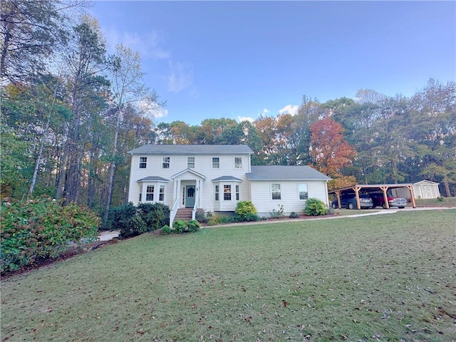 colonial inspired home featuring a carport and a front lawn