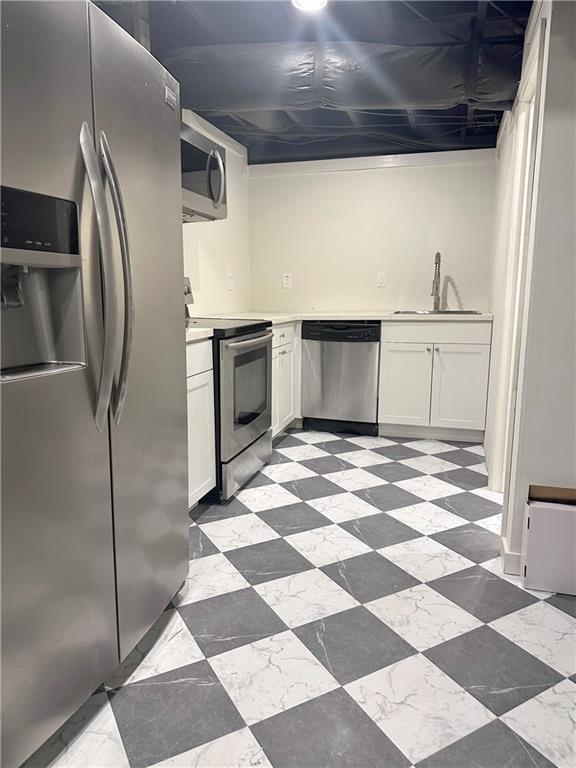 kitchen with sink, white cabinets, and appliances with stainless steel finishes