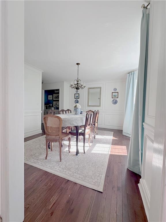 dining room with an inviting chandelier and dark wood-type flooring