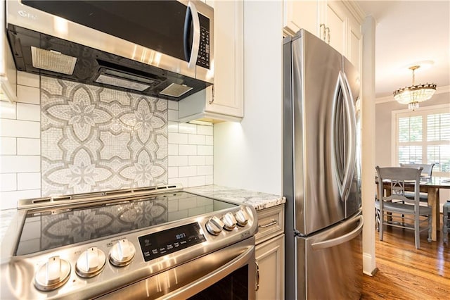 2197 Fairway Cir NE, Brookhaven, GA 30319 - kitchen featuring appliances with stainless steel finishes, tasteful backsplash, wood finished floors, light stone countertops, and ornamental molding