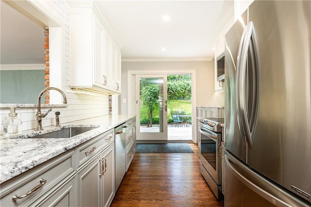 2197 Fairway Cir NE, Brookhaven, GA 30319 - kitchen featuring appliances with stainless steel finishes, a sink, light stone counters, dark wood finished floors, and ornamental molding