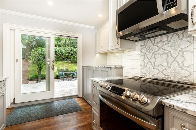 2197 Fairway Cir NE, Brookhaven, GA 30319 - kitchen with appliances with stainless steel finishes, crown molding, tasteful backsplash, dark wood finished floors, and light stone counters