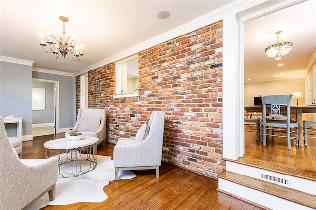 2197 Fairway Cir NE, Brookhaven, GA 30319 - living area with a chandelier, wood finished floors, brick wall, ornamental molding, and baseboards