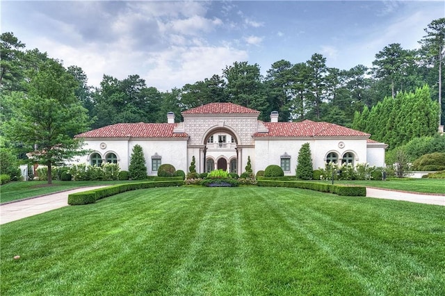 mediterranean / spanish-style house featuring a front lawn