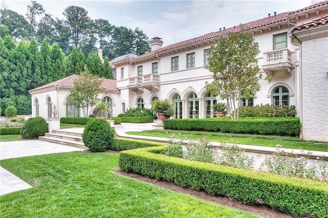 mediterranean / spanish home featuring a front lawn