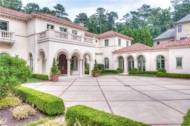 rear view of house featuring a balcony and a patio