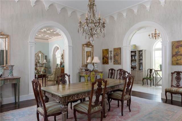 dining space with a notable chandelier, dark hardwood / wood-style flooring, crown molding, and decorative columns