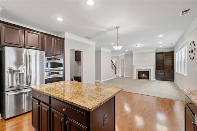 kitchen with crown molding, stainless steel appliances, dark brown cabinetry, a kitchen island, and decorative light fixtures