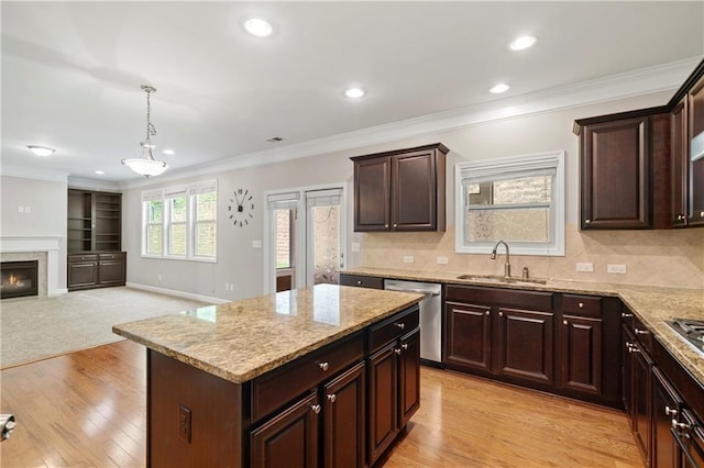 kitchen featuring a kitchen island, decorative light fixtures, dishwasher, sink, and crown molding