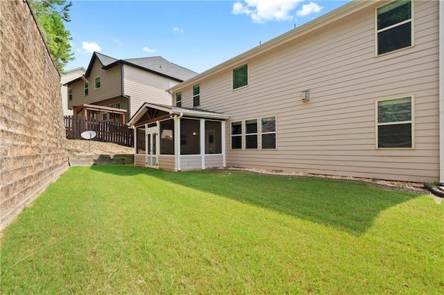 back of house with a sunroom and a yard