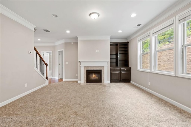 unfurnished living room with ornamental molding and carpet