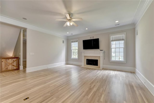 unfurnished living room featuring ornamental molding, light wood-type flooring, a fireplace, and baseboards