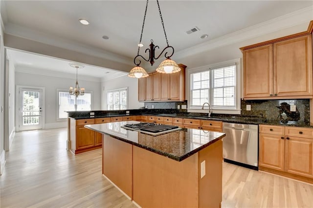 kitchen featuring a peninsula, a sink, visible vents, appliances with stainless steel finishes, and decorative backsplash