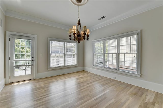 unfurnished dining area featuring a chandelier, wood finished floors, visible vents, baseboards, and ornamental molding