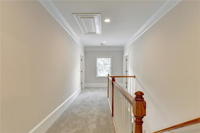 hallway featuring carpet floors, attic access, ornamental molding, an upstairs landing, and baseboards