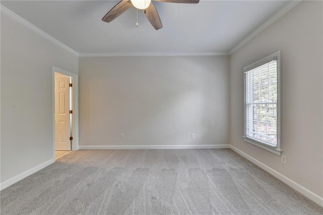 spare room featuring light carpet, crown molding, baseboards, and ceiling fan