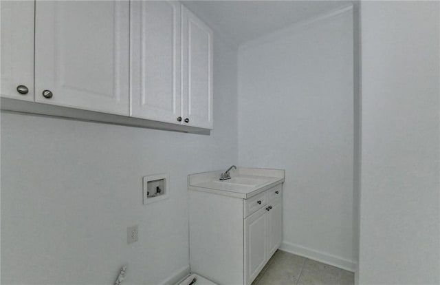 laundry room featuring cabinet space, baseboards, washer hookup, a sink, and light tile patterned flooring