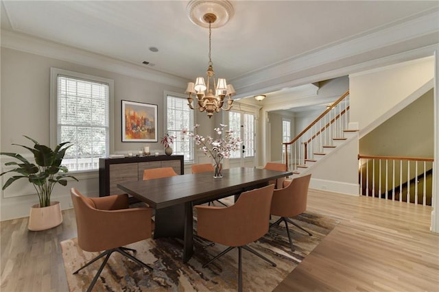 dining area with baseboards, visible vents, ornamental molding, wood finished floors, and stairs