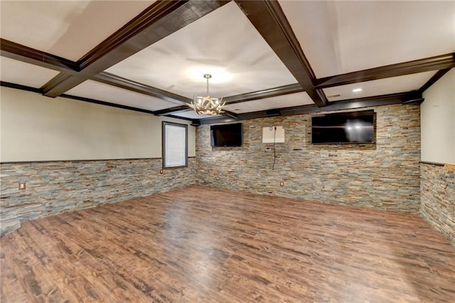 unfurnished living room featuring an inviting chandelier, beam ceiling, coffered ceiling, and wood finished floors