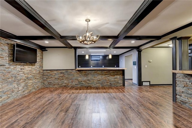 unfurnished living room with beam ceiling, coffered ceiling, decorative columns, and wood finished floors