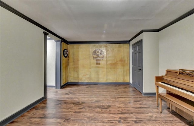 unfurnished room featuring baseboards, wood finished floors, and crown molding