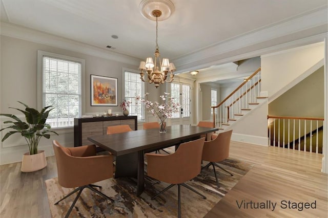 dining area featuring baseboards, stairs, ornamental molding, and wood finished floors