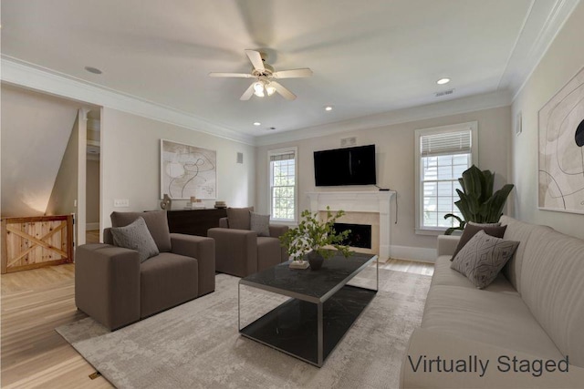 living room with ornamental molding, a healthy amount of sunlight, and wood finished floors