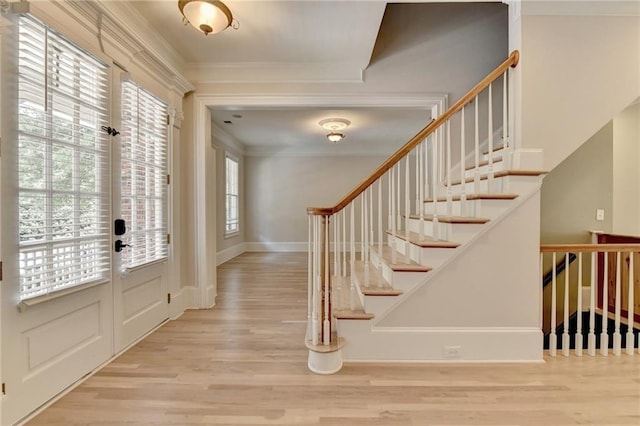 entryway featuring baseboards, ornamental molding, wood finished floors, stairs, and french doors