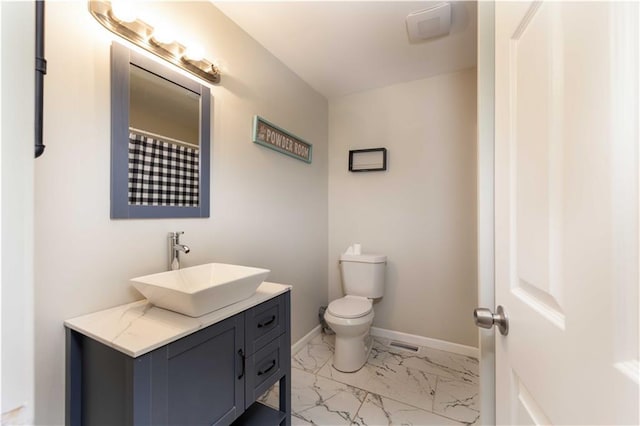 bathroom with vanity, marble finish floor, baseboards, and toilet