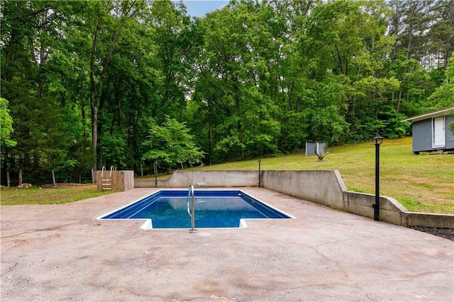 outdoor pool featuring an outbuilding, a patio area, a yard, and a storage shed