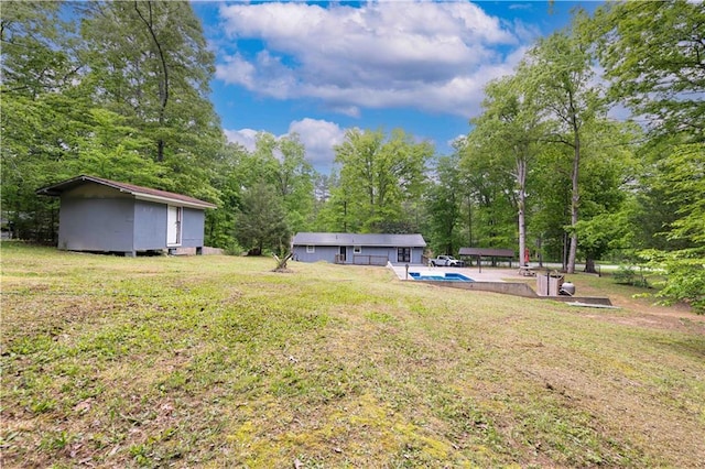 view of yard with a storage shed, an outbuilding, and an outdoor pool