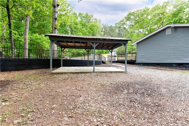 view of yard with a detached carport, fence, and driveway