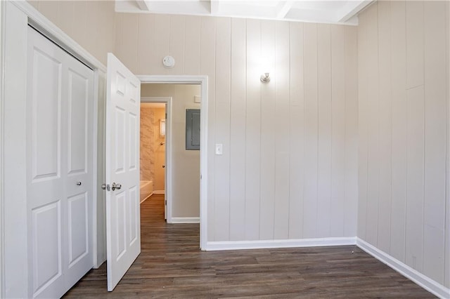 interior space featuring electric panel, baseboards, and dark wood finished floors