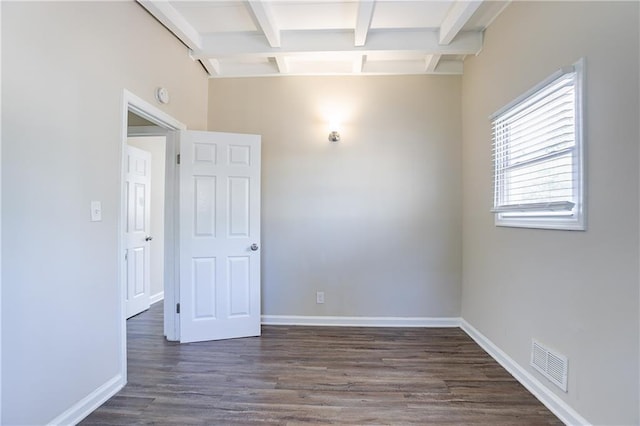 spare room featuring visible vents, baseboards, beamed ceiling, and dark wood finished floors