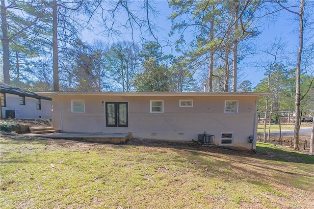 back of house featuring cooling unit, a yard, french doors, crawl space, and brick siding