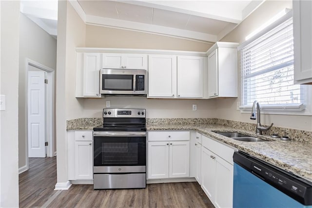 kitchen with a sink, dark wood finished floors, stainless steel appliances, white cabinets, and light stone countertops