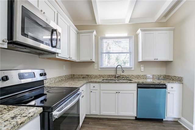 kitchen featuring beamed ceiling, white cabinetry, stainless steel appliances, and a sink