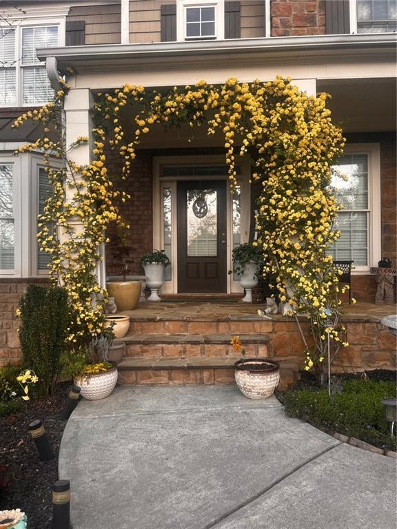 7113 Artisans Way, Flowery Branch, GA 30542 - doorway to property featuring covered porch
