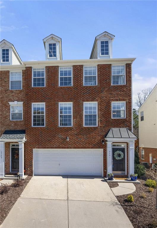 view of front of house featuring brick siding, driveway, and an attached garage