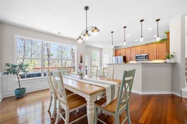 dining area with recessed lighting, visible vents, a decorative wall, and hardwood / wood-style floors