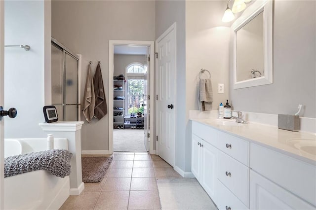 bathroom with tile patterned flooring, a shower with door, and vanity