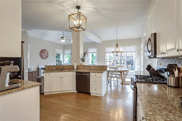 kitchen with stainless steel appliances, white cabinetry, decorative light fixtures, and sink